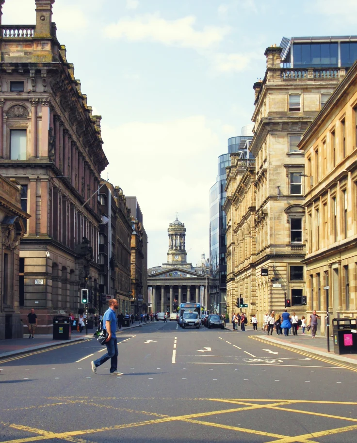 man standing in street next to buildings during daytime