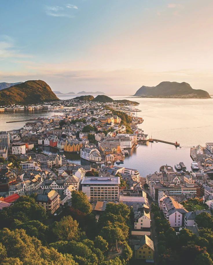 view of city next to body of water with mountain in the background