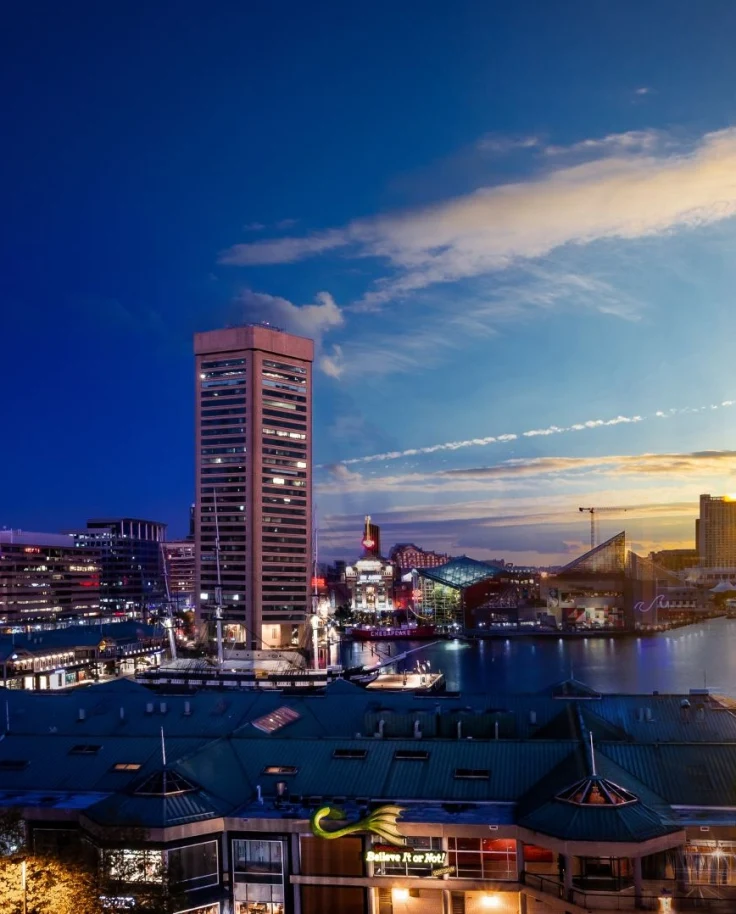 Day to night view of a city harbor.