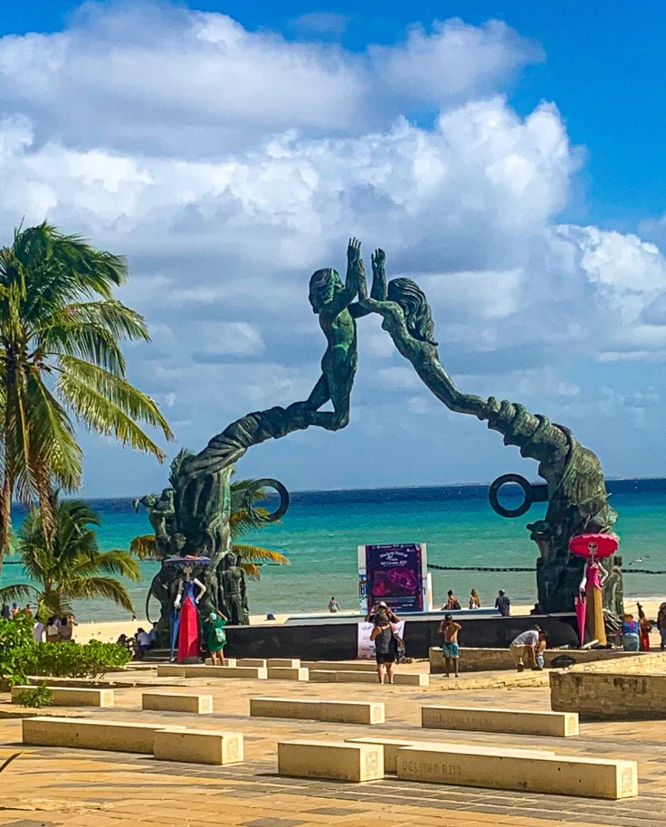 Statue of a man and woman on a beach.