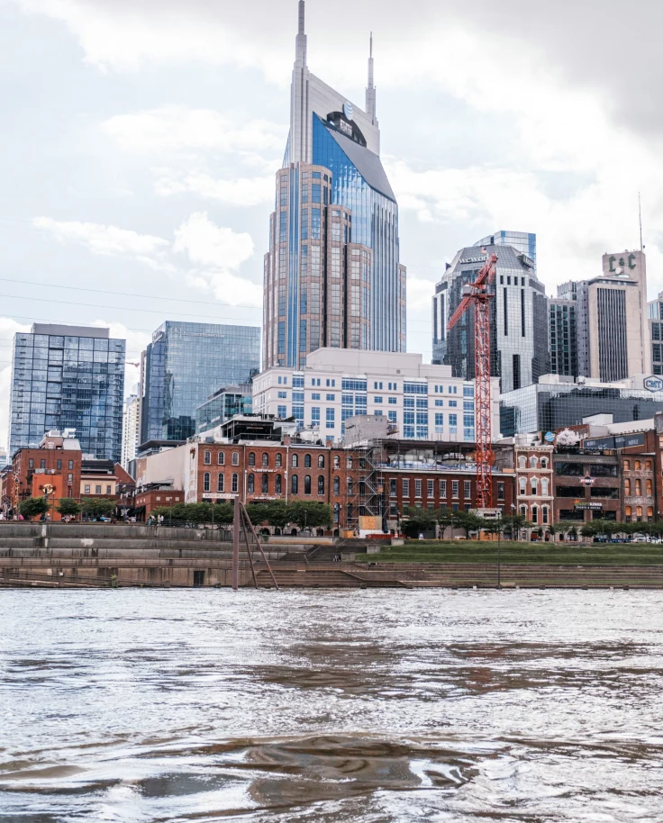 A body of water in front of tall city buildings during the daytime