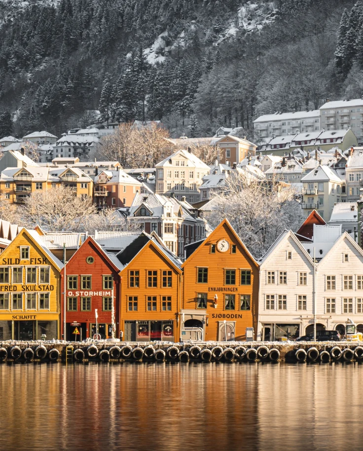 town on the water with colorful buildings and snowy mountains