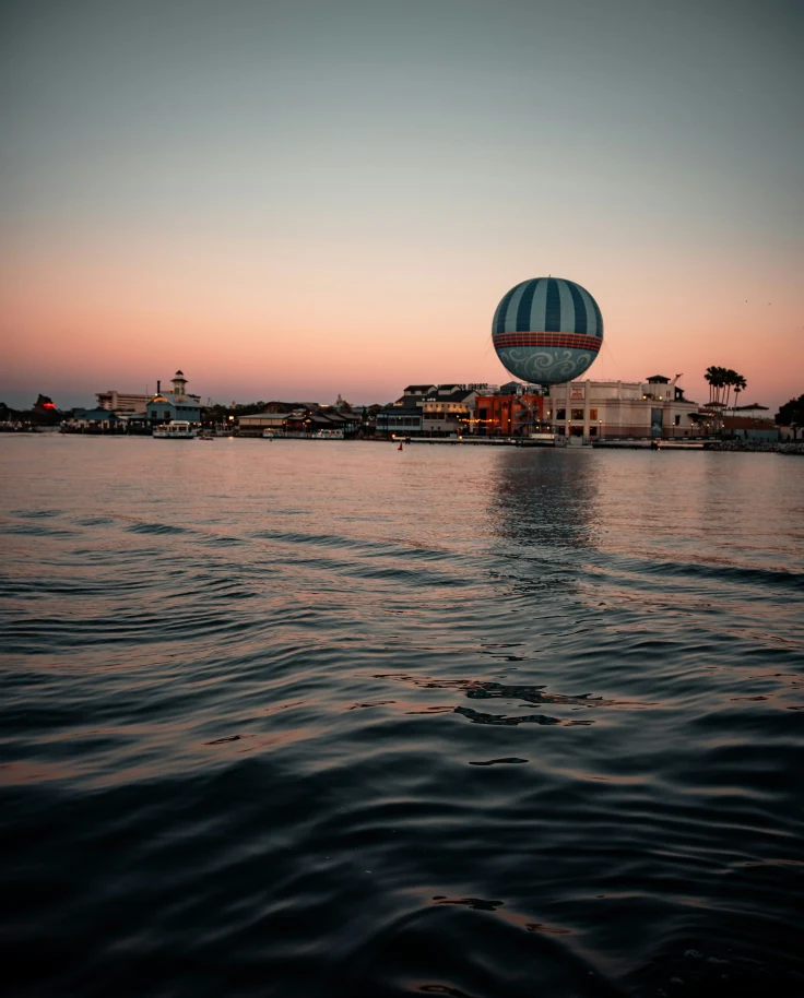Sunset over the water with a Disney resort in the distance.
