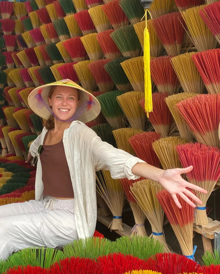 Travel advisor Isabel Smallman sitting in a store surrounded by colorful incense sticks on display.