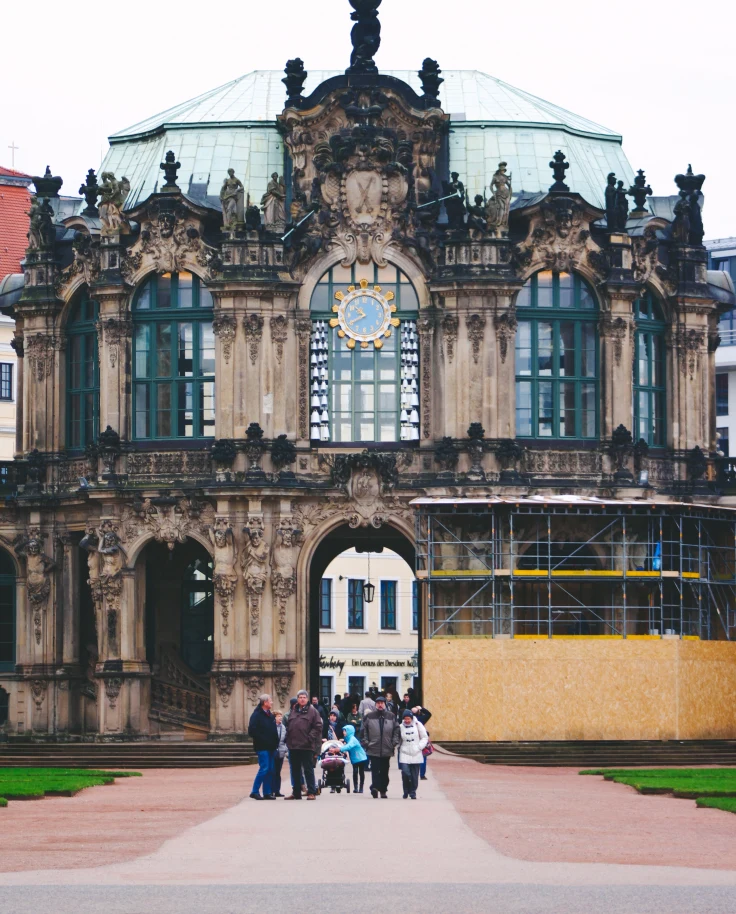 People walking in front of brown concrete building in Dresden.