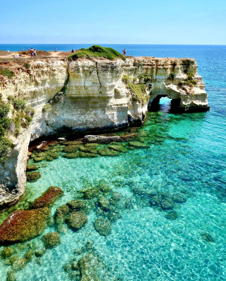 Puglia aerial coastal views with blue waters and rugged rocks.