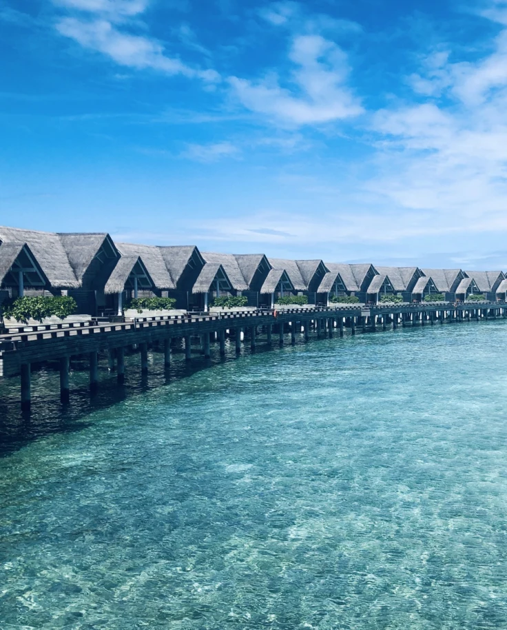 a row of bungalows over turquoise water