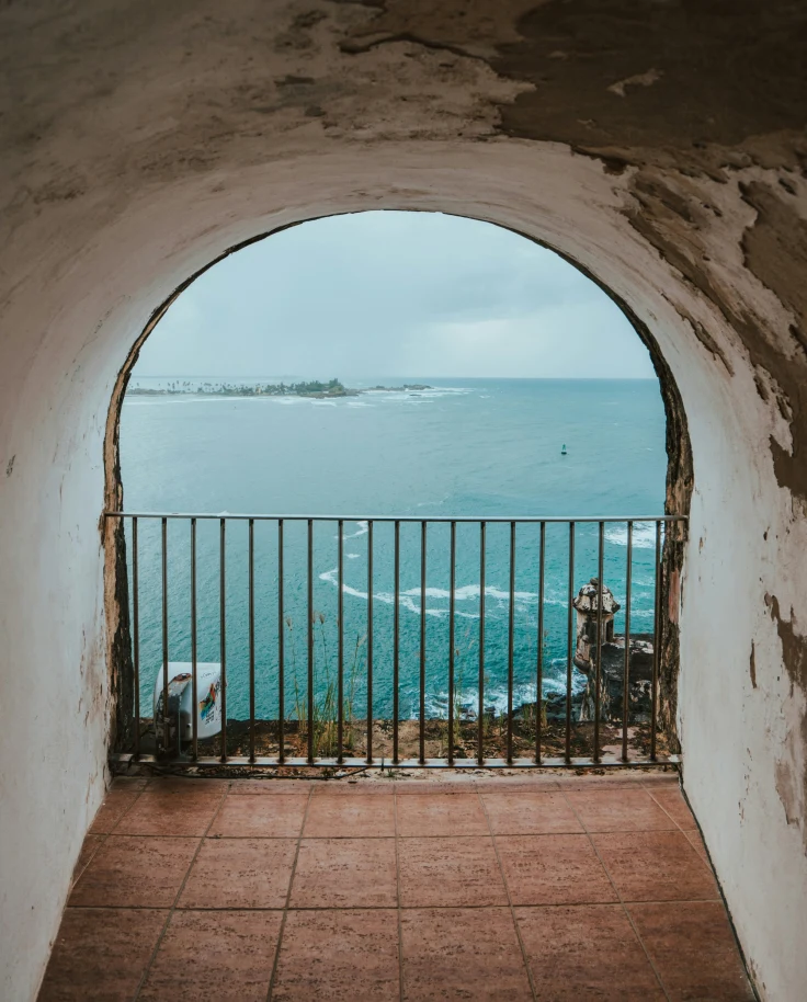 A picture of a metal fence near the blue sea during the daytime.