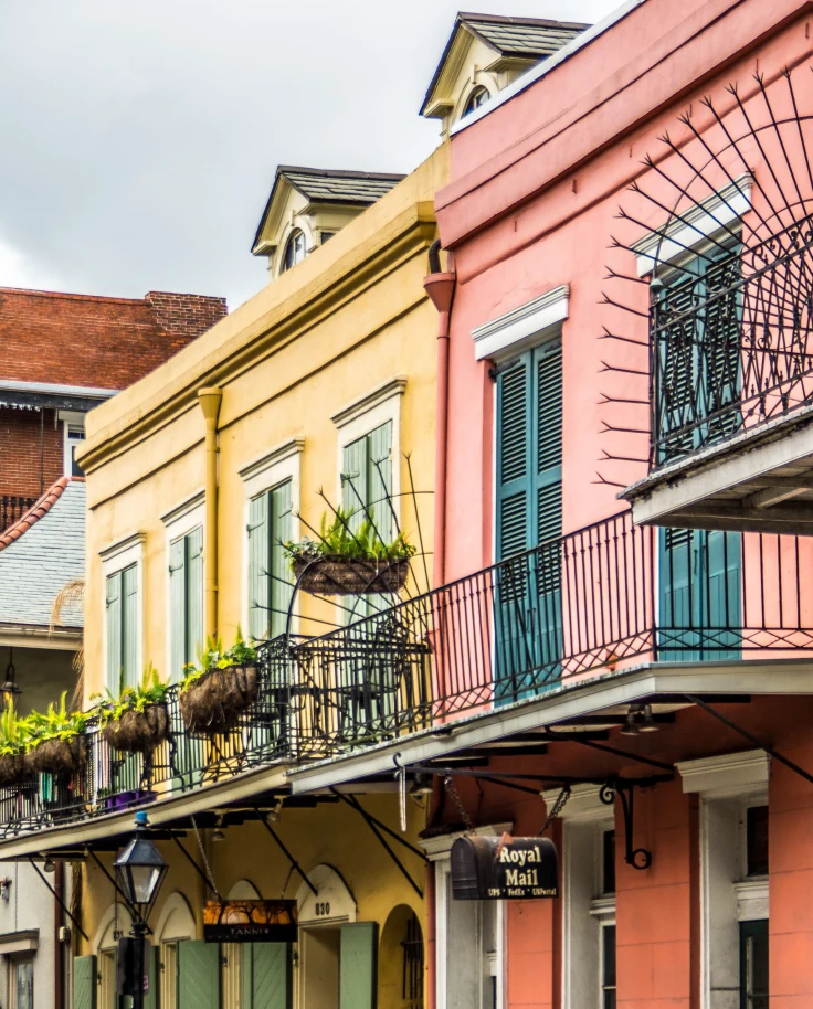 Pink and yellow buildings with a man walking on a side walk.