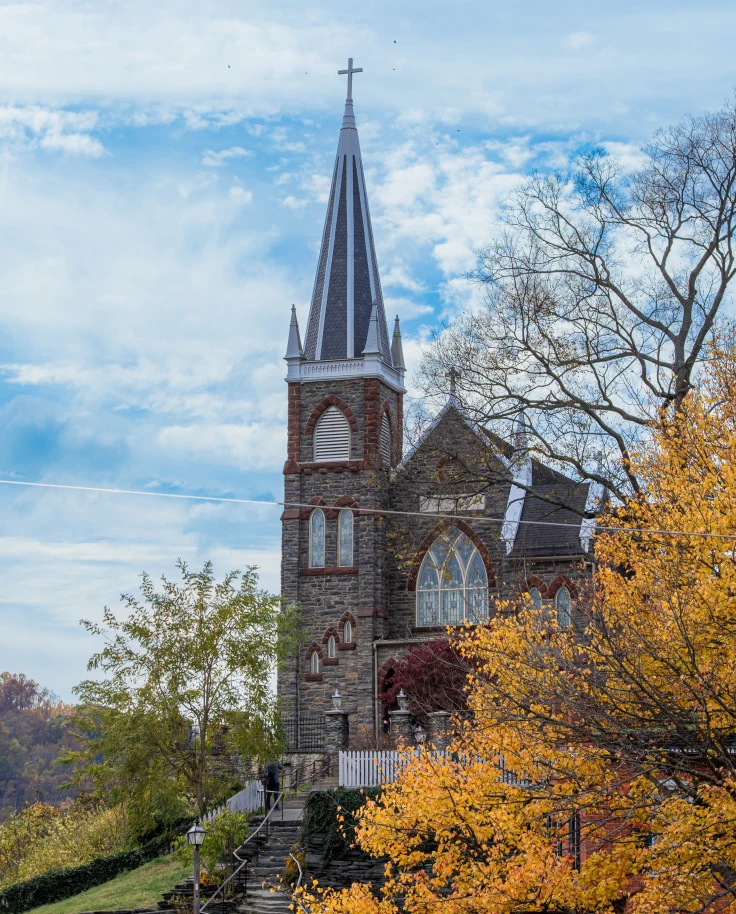 A church with a tree with autumn leaves.