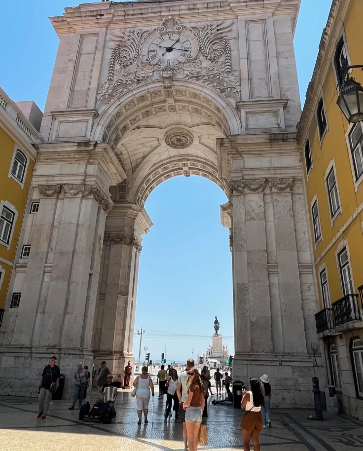 A tall, arched structure between yellow buildings