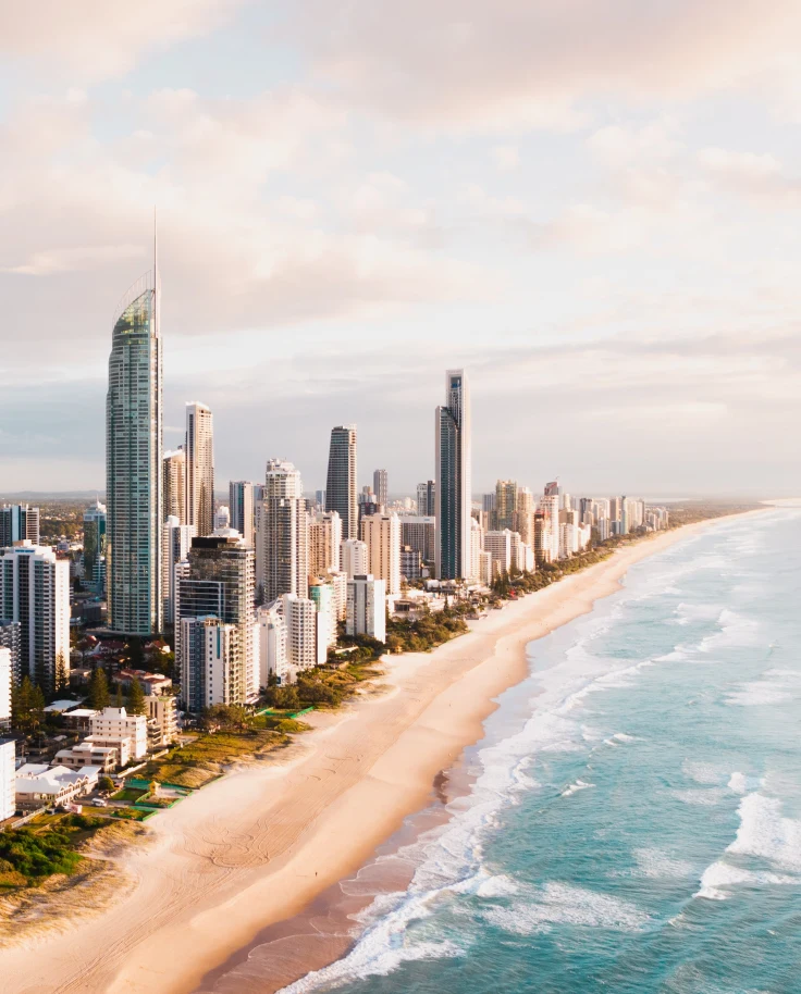 skyscrapers next to beach and ocean during sunset