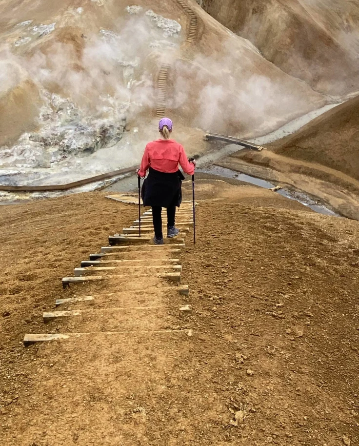 A woman hiking in peach shirt.