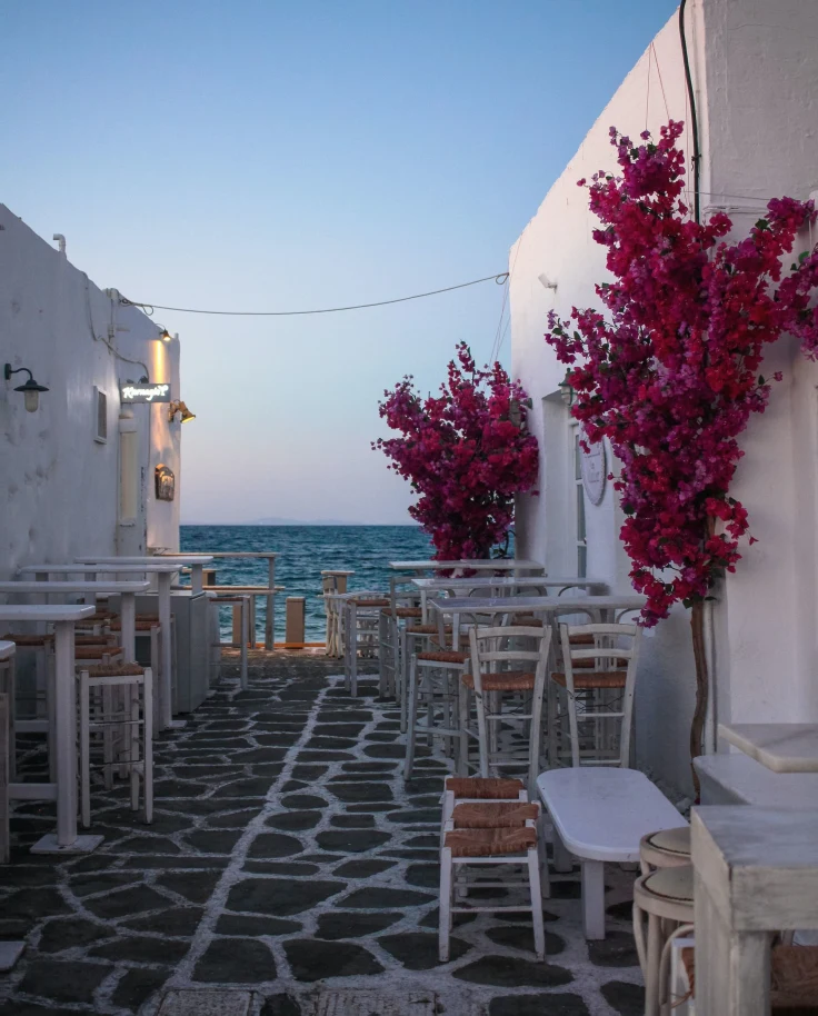 White wooden tables and chairs near body of water