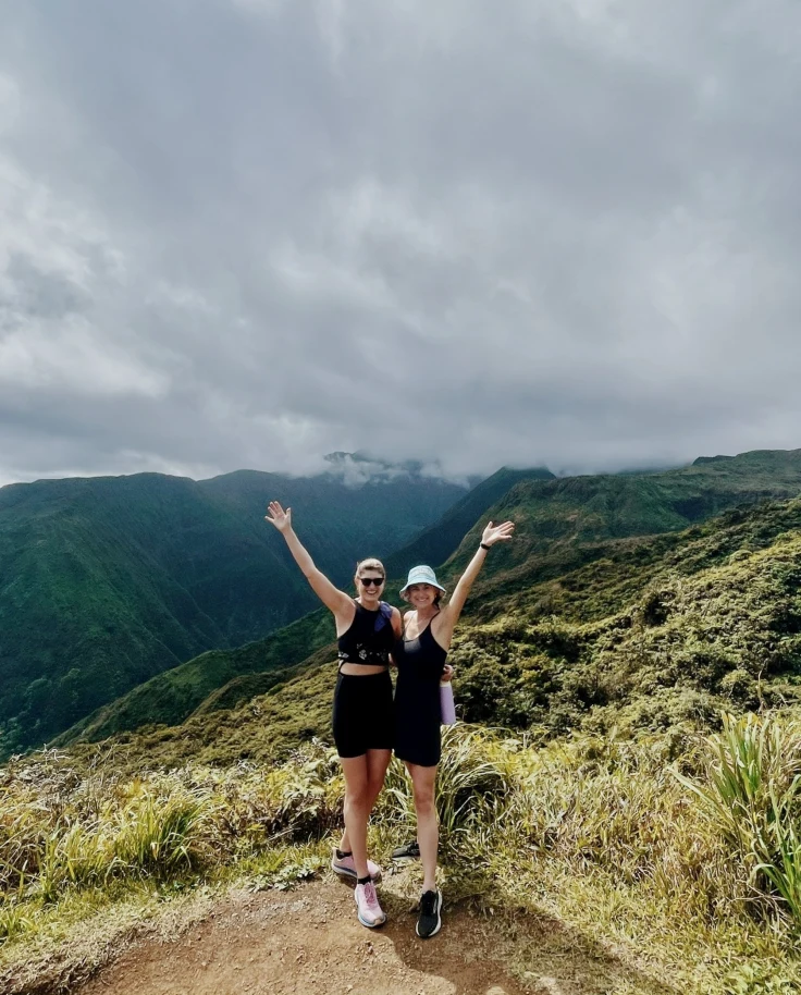 Two people at the top of a mountain posing for a photograph together