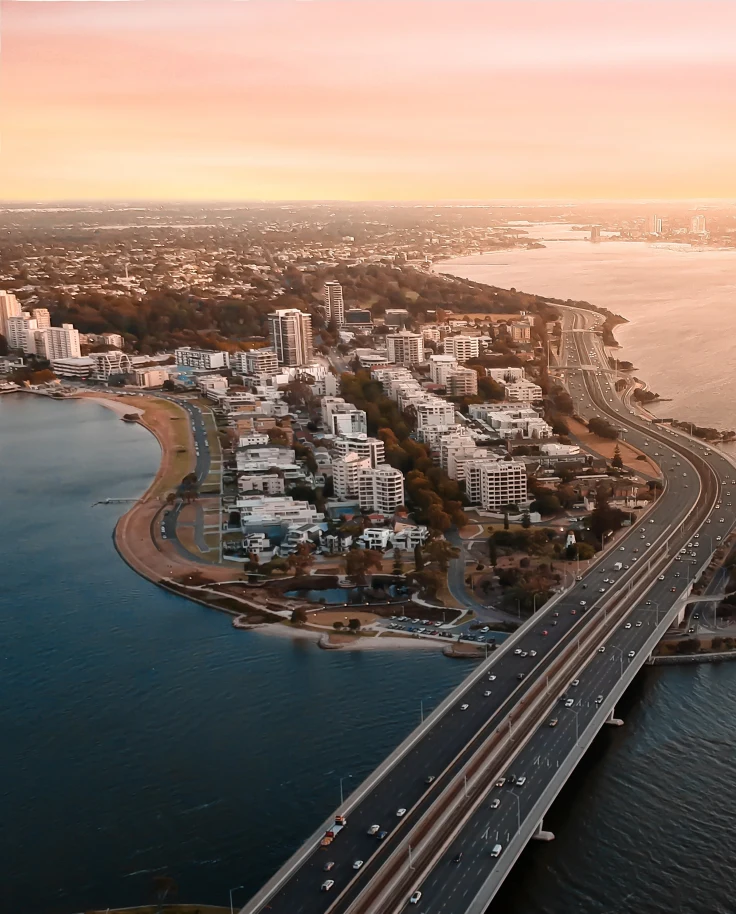 aerial view of bridge next to city during sunset