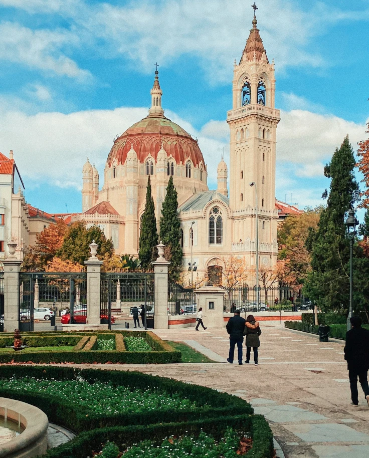 People standing next to gardens and building during daytime