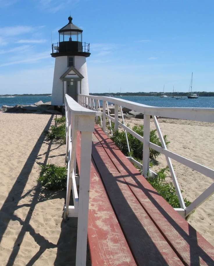 A lighthouse near a beach during daytime.