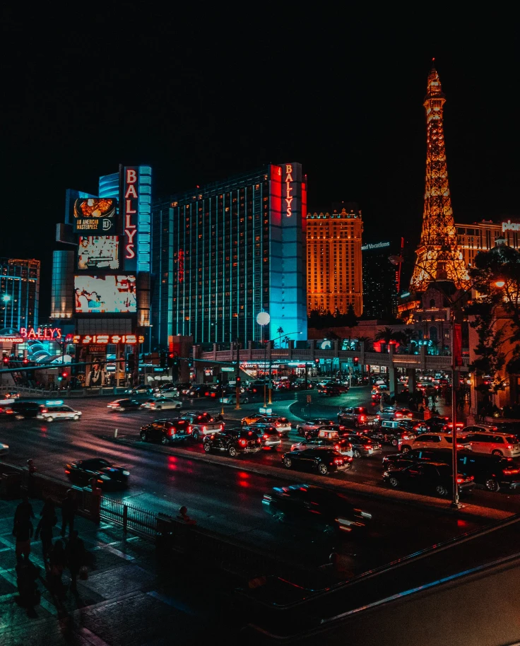 Night view of Las Vegas with high rise buildings, streets, traffic and lighting.
