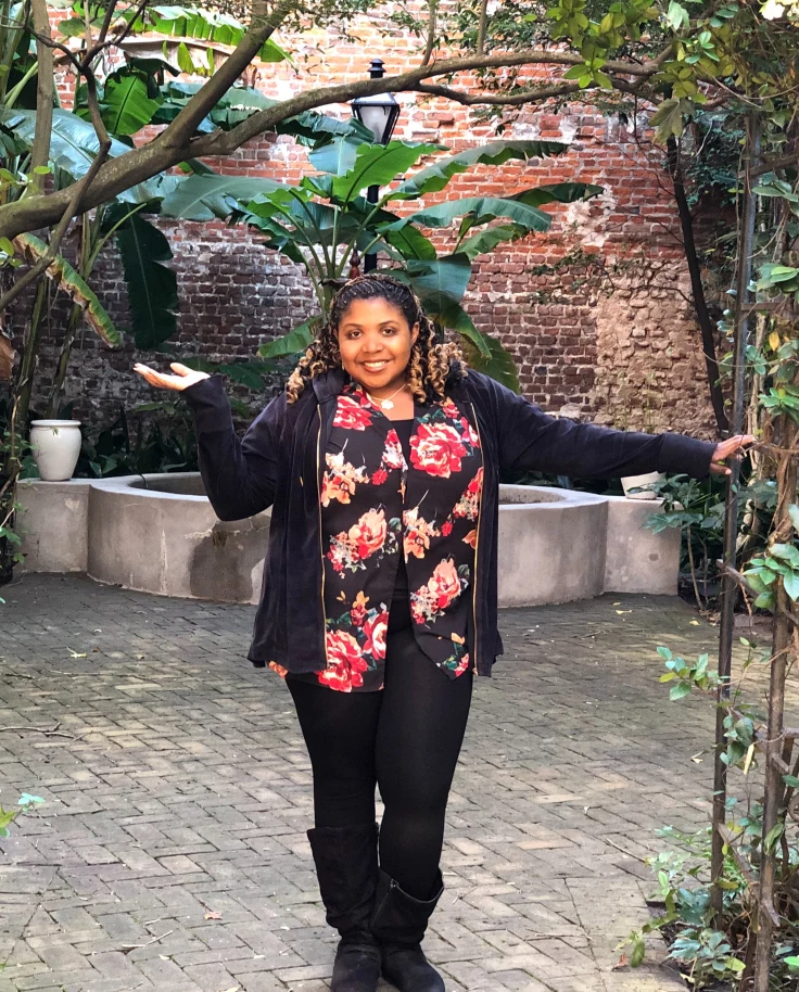 Advisor posing in a courtyard area