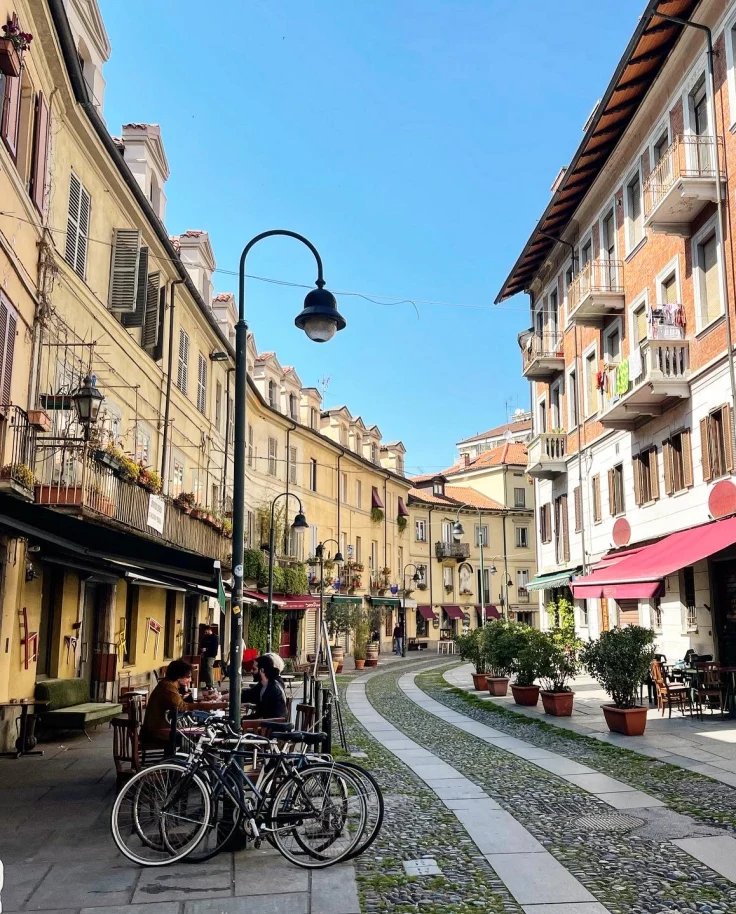 Street view of historical buildings winding along a cobbled street on a clear day.