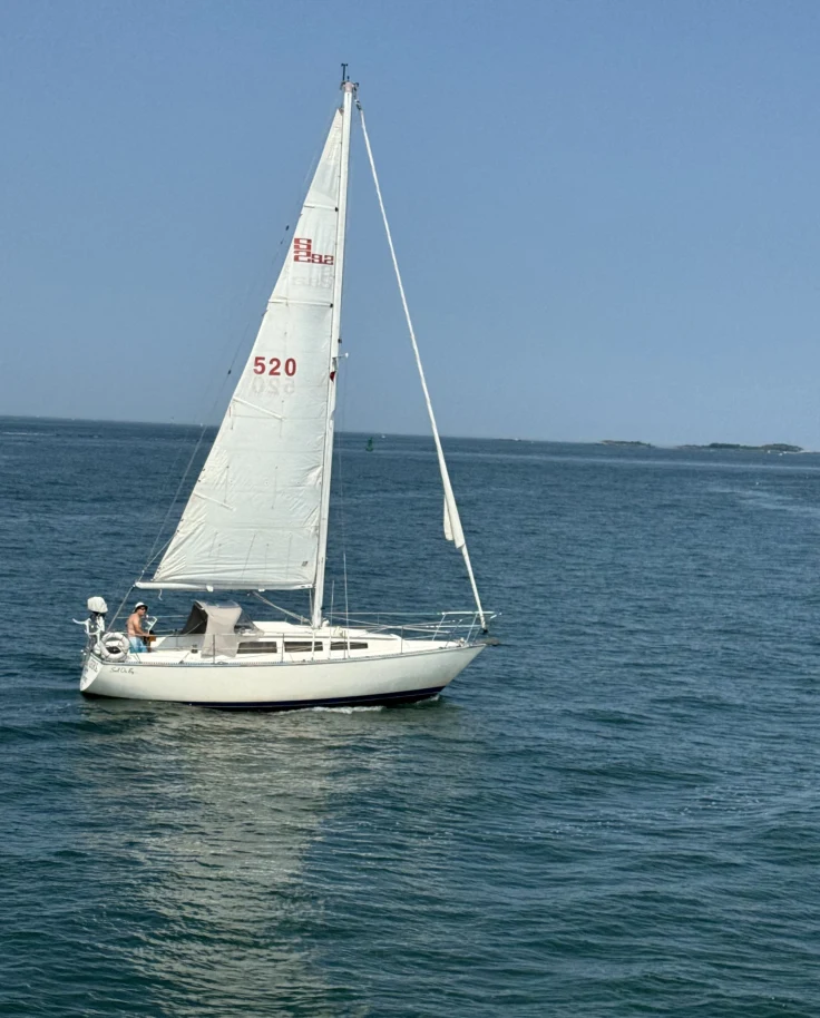 A white sailboat with the sail number 520 on open water.