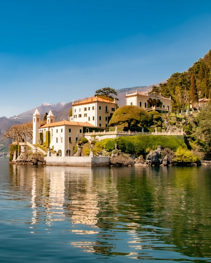 White houses with orange roofs sitting lakeside at Lake Como in Italy
