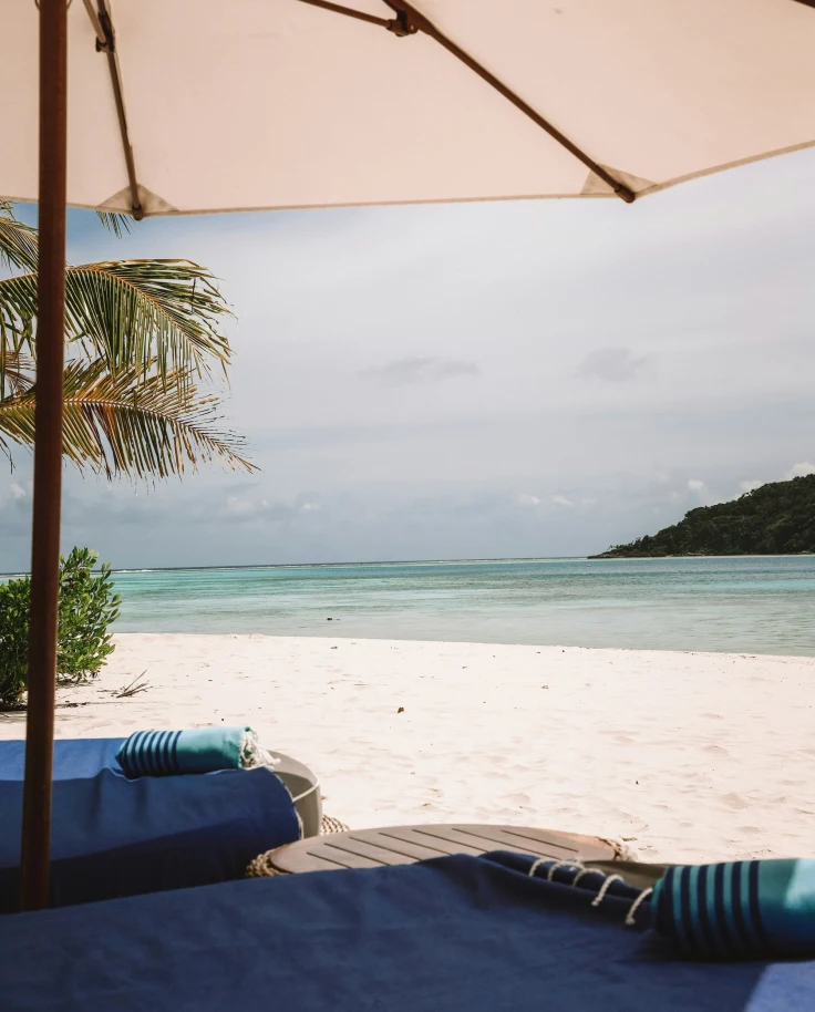 A picture of a beige umbrella near a beach during daytime.