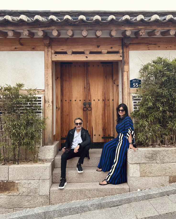 Two people posing for a photo in front of a building