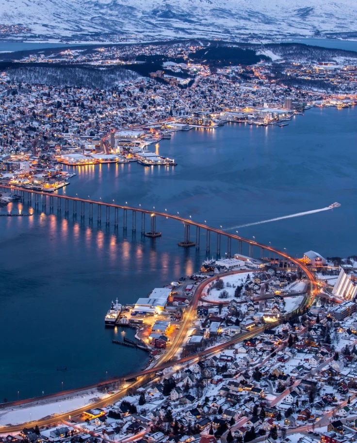 snowy city with lights and a bridge