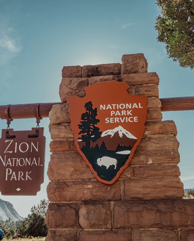 A board with writing Zion National Park