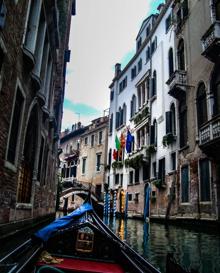 Boat in a city canal between buildings.