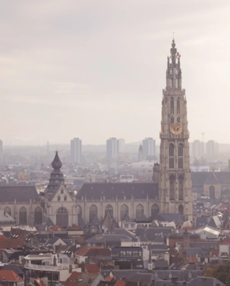 A view of Antwerp's skyline and architecture on a foggy day.