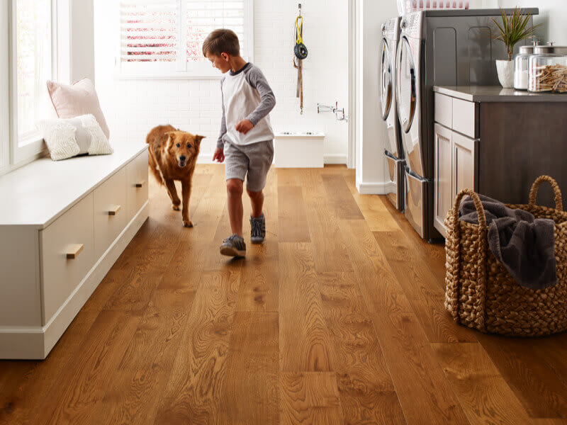boy running through laundry room with dog following on wood-look, pet-friendly flooring
