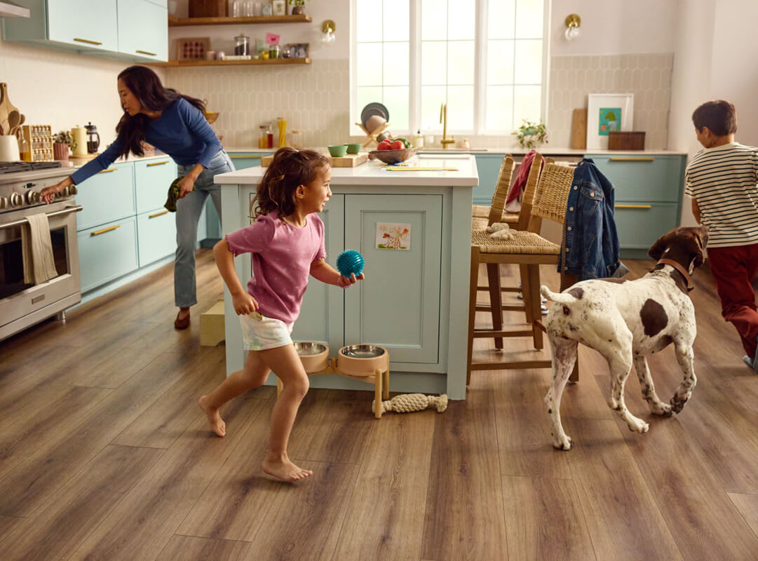 children and dog running around a kitchen with luxury vinyl flooring