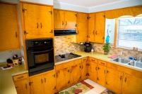 A kitchen with wooden cabinets and a stove