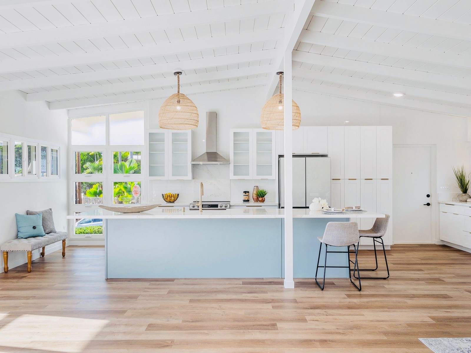 Spacious open-concept kitchen and living room featuring light luxury vinyl flooring, a large island by Degraaf Interiors in Grand Rapids, MI.