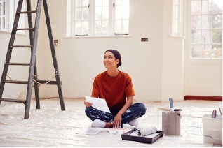 A person sitting on the floor with a paperDescription automatically generated