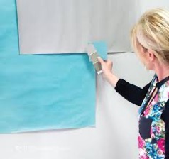 A person painting a wallDescription automatically generated