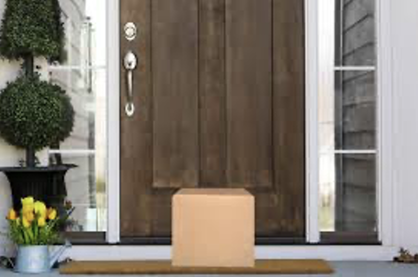 A box on a mat in front of a doorDescription automatically generated