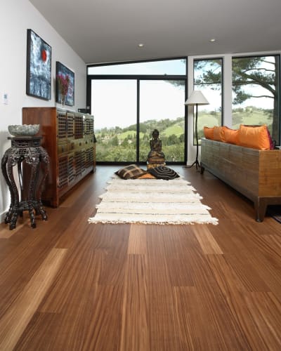  A dog carrying a gingerbread man toy in its mouth while walking down a hallway with COREtec® wood look flooring in a medium dark color)