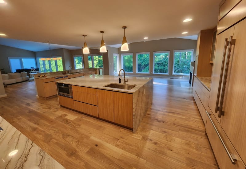 Hardwood floor installation in a modern Frontenac kitchen with large windows and natural light.
