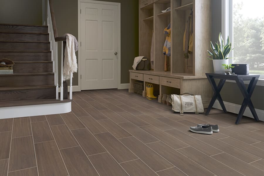 wood-look tile flooring in home with earthy walls