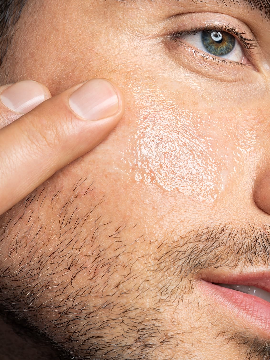 A closeup of a man touching his face