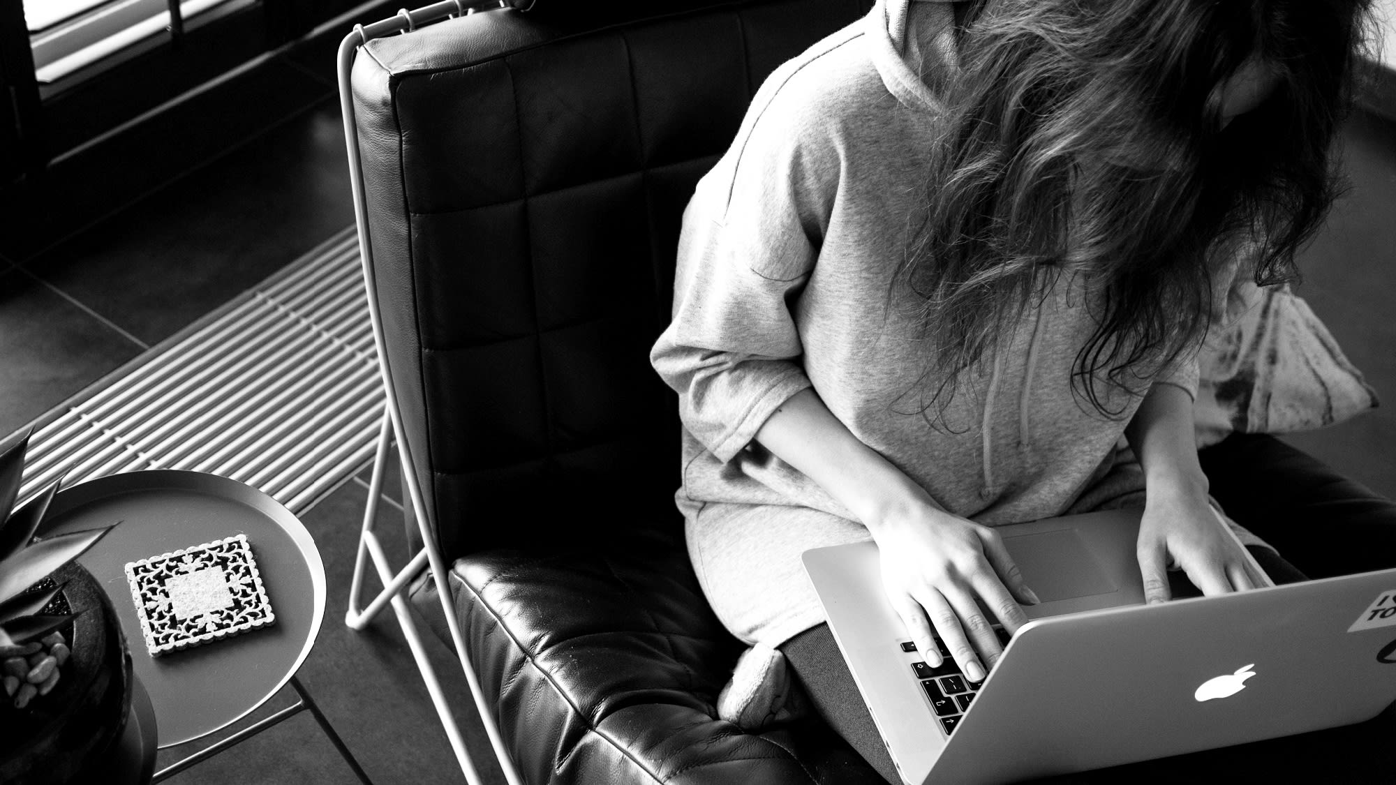 Woman sitting in a chair on a laptop