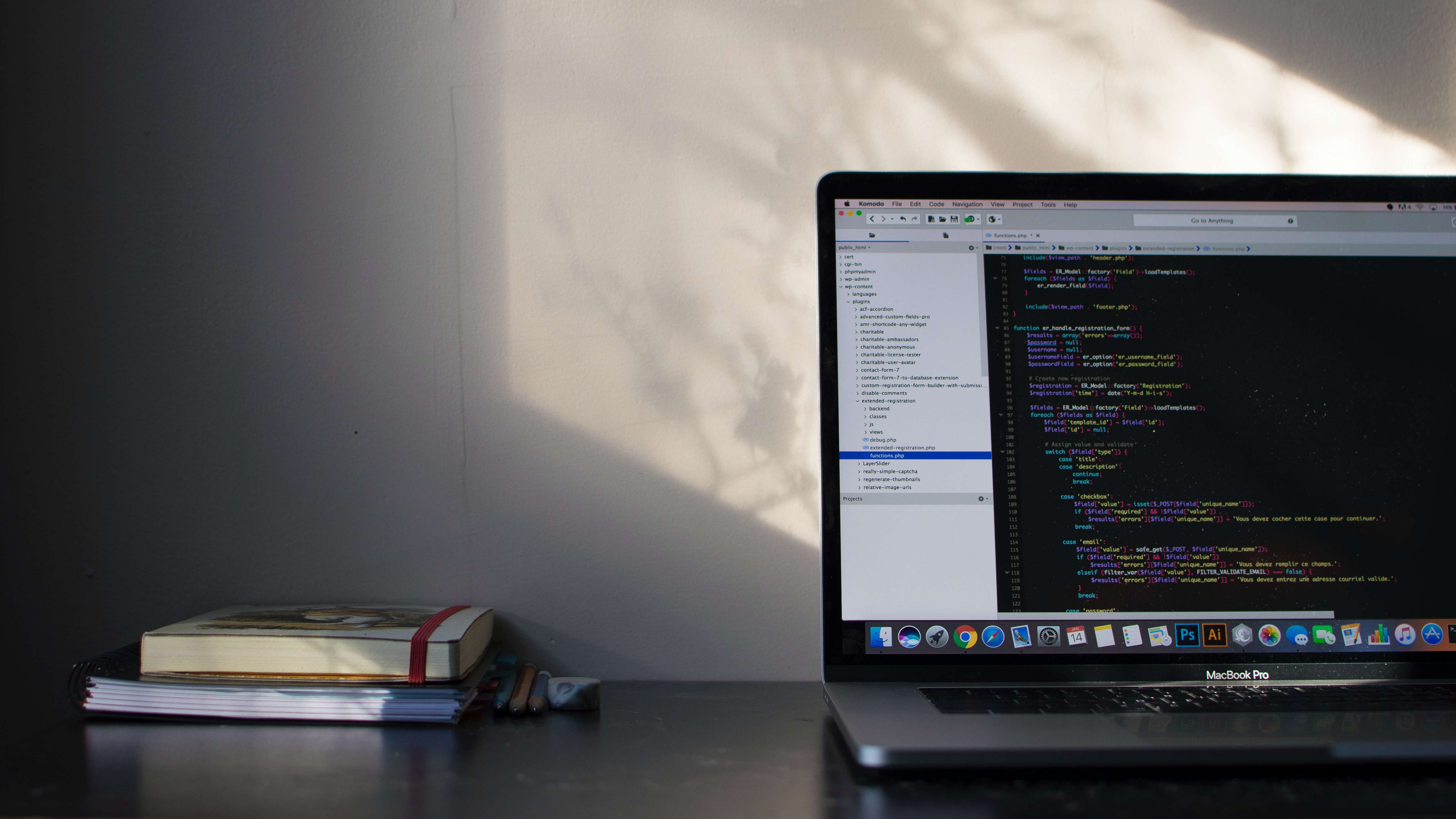 Photo by Emile Perron via Unsplash of a computer sitting on a table with a few books