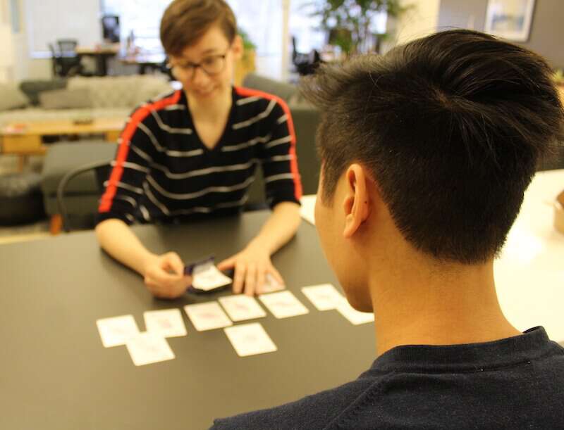 Individuals discussing the cards drawn from a deck of Formidable UX cards