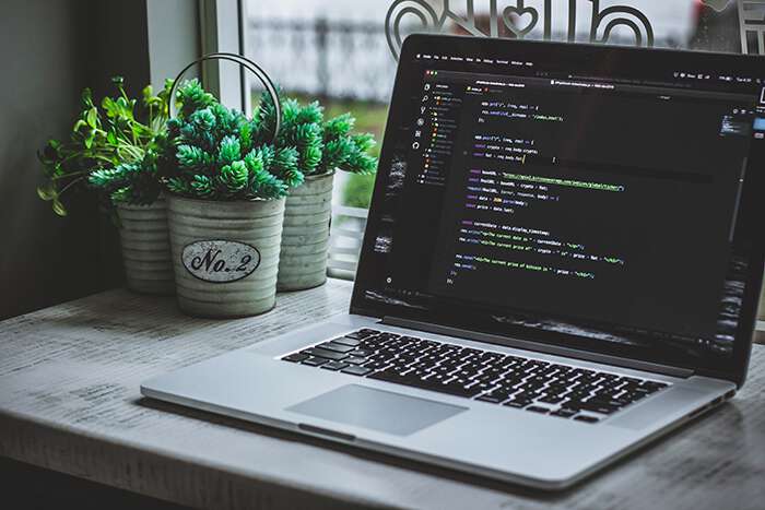 Photo by Safar Safarov on Unsplash of a laptop on a desk by a window