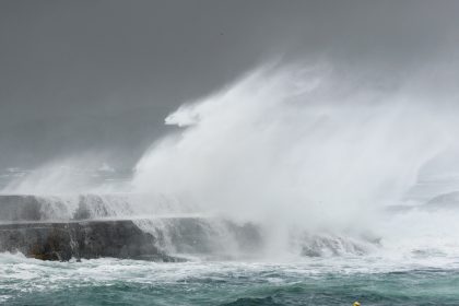 Bølger som slår mot klipper. Foto.