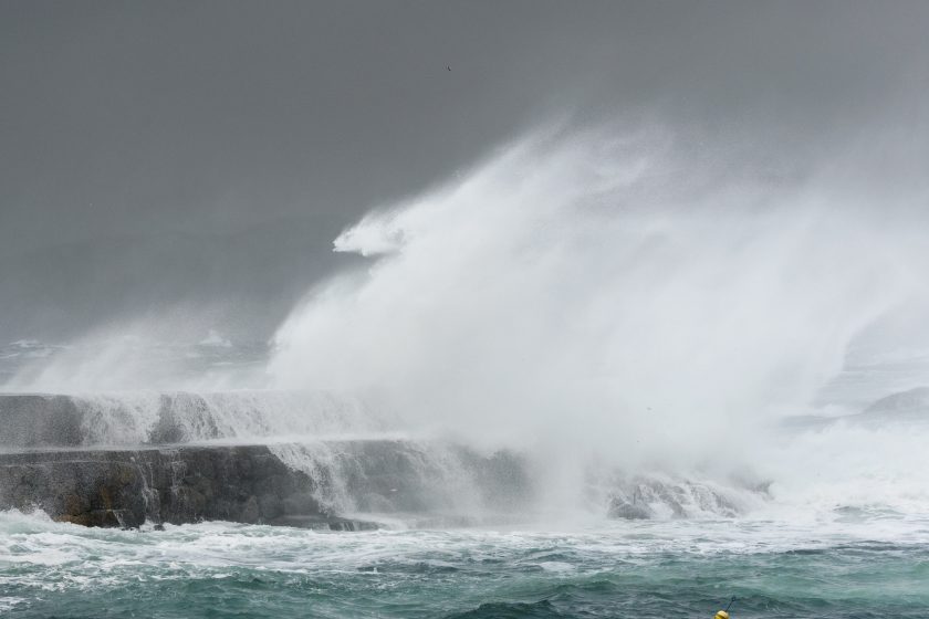Bølger som slår mot klipper. Foto.